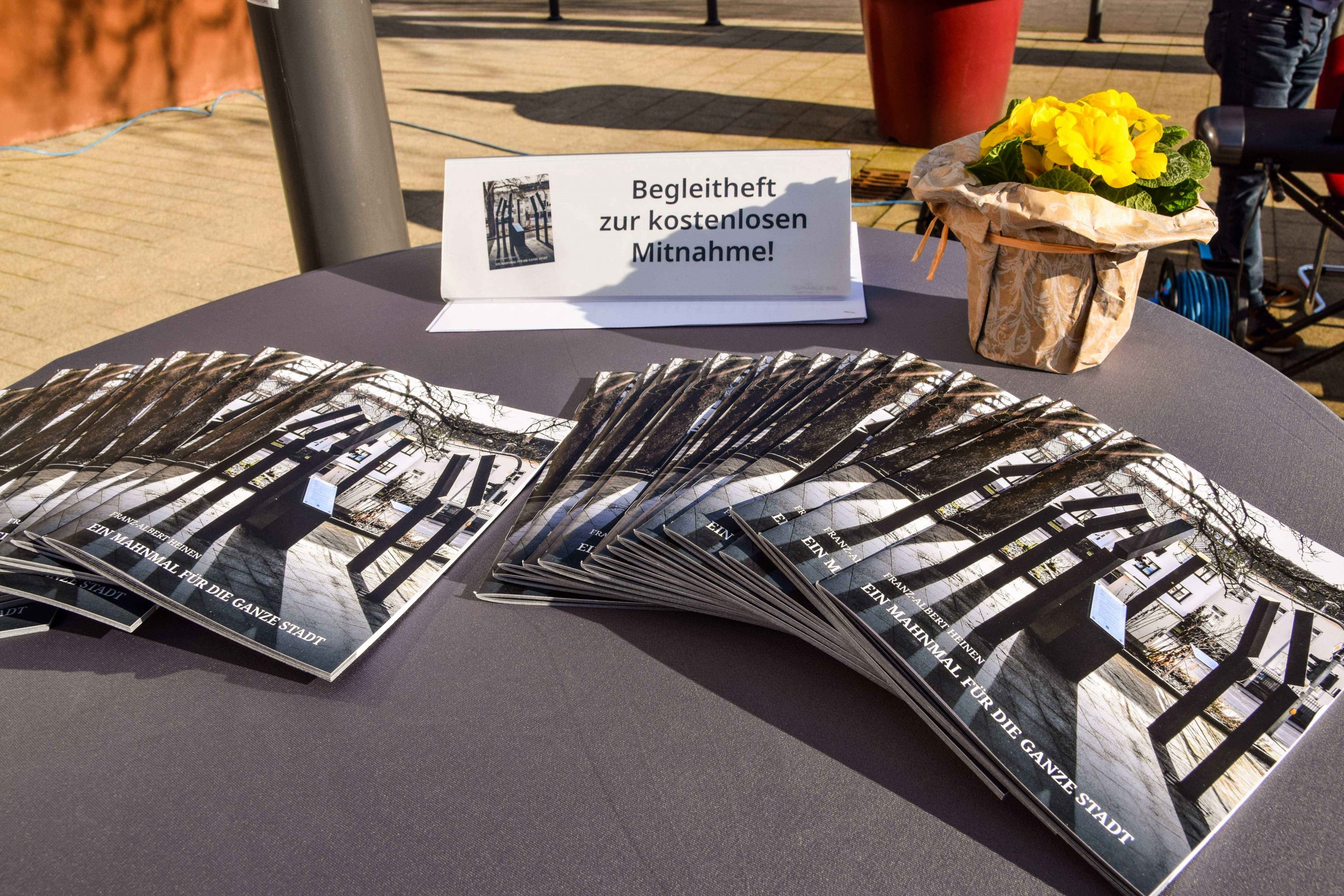 Zur kostenlosen Mitnahme ausgelegte Begleithefte zum Mahnmal am Tag der Denkmalenthüllung am 7. März 2025